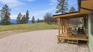 Un espace extérieur abrité, doté d’un chemin de gravier, d’une terrasse en bois et de sièges.