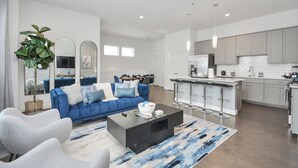 Un salon moderne avec un canapé bleu, une table basse et un grand miroir.