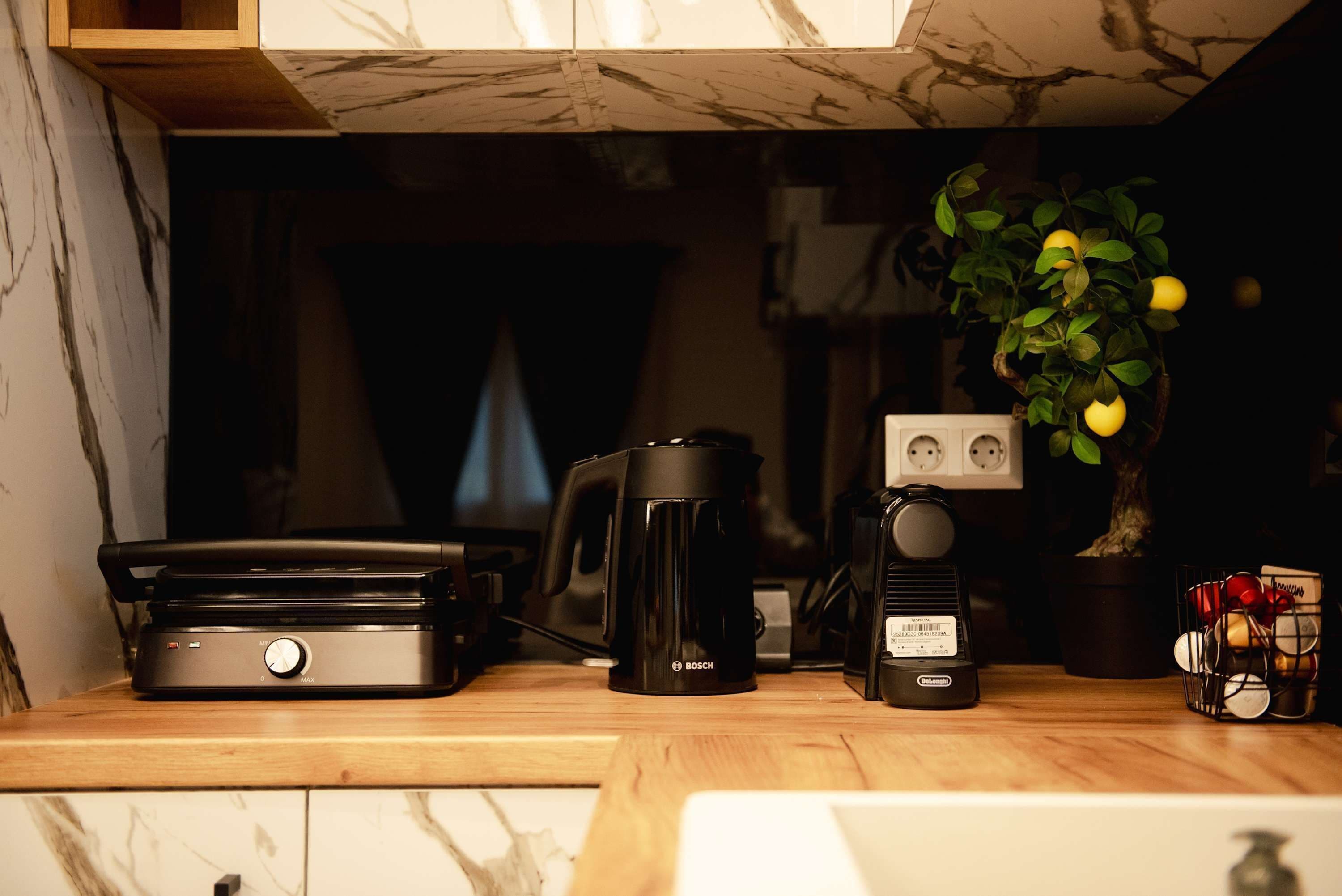 A kitchen counter with a coffee maker, a kettle, and a radio.
