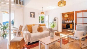 A spacious living area with a sofa, chairs, a dining table, and a kitchen in the background. - Villa María Sayalonga by Ruralidays (Málaga)