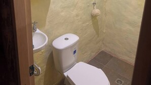 Ein kleines, kompaktes Badezimmer mit Toilette, Waschbecken und Dusche.
