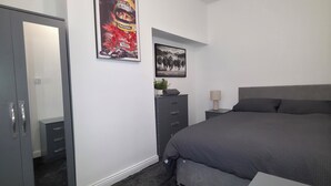 A bedroom with a bed, a dresser, a mirror, and two framed pictures on the wall. - Costa Home Middlesbrough (Middlesbrough)