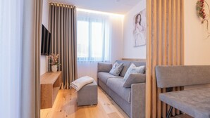 A modern living room with a sofa, ottoman, and a bench.