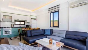 A modern living room with a sofa, a coffee table, and a dining area with chairs. - Holiday villa in Kaş / Antalya, on the most turquoise sea of the Mediterranean. (Antalya)