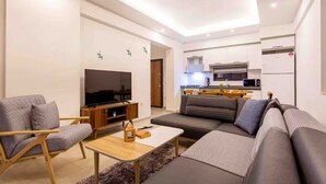 A modern living room with a sofa, a TV, and a small table. - Holiday villa in Kaş / Antalya, on the most turquoise sea of the Mediterranean. (Antalya)
