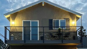 A two-story house with a balcony, a stone facade, and a flat roof. - FIFA Fans! Brand-NEW 1 Bedroom, 1 Bath Apartment  (San Jose)