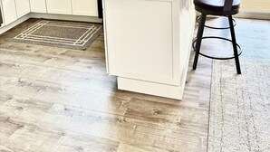 A modern kitchen with white cabinetry, a large island, and a view of the outdoors. - FIFA Fans! Brand-NEW 1 Bedroom, 1 Bath Apartment  (San Jose)