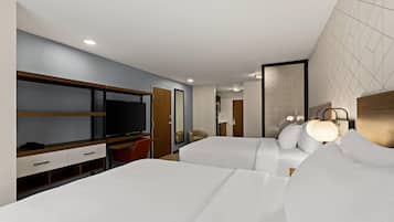 A hotel room with two beds, a desk with a TV, and a wardrobe.