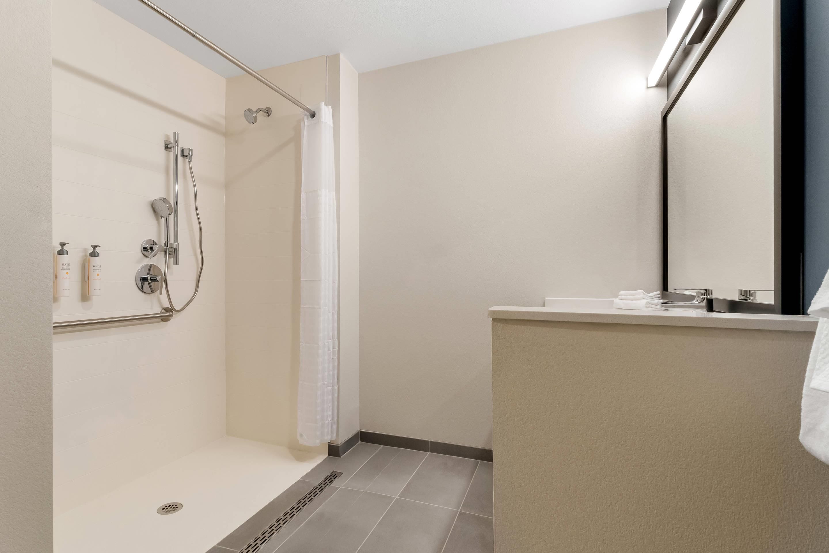 A modern bathroom with a shower, a toilet, and a sink.
