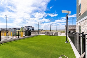 A rooftop patio with artificial grass, outdoor seating, and a clear view of the surrounding area. - Everhome Suites Denver Airport (Denver)