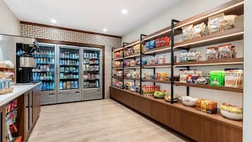 Un kiosque proposant des collations et des boissons, équipé de distributeurs de boissons réfrigérés et de présentoirs remplis de collations et de chips.