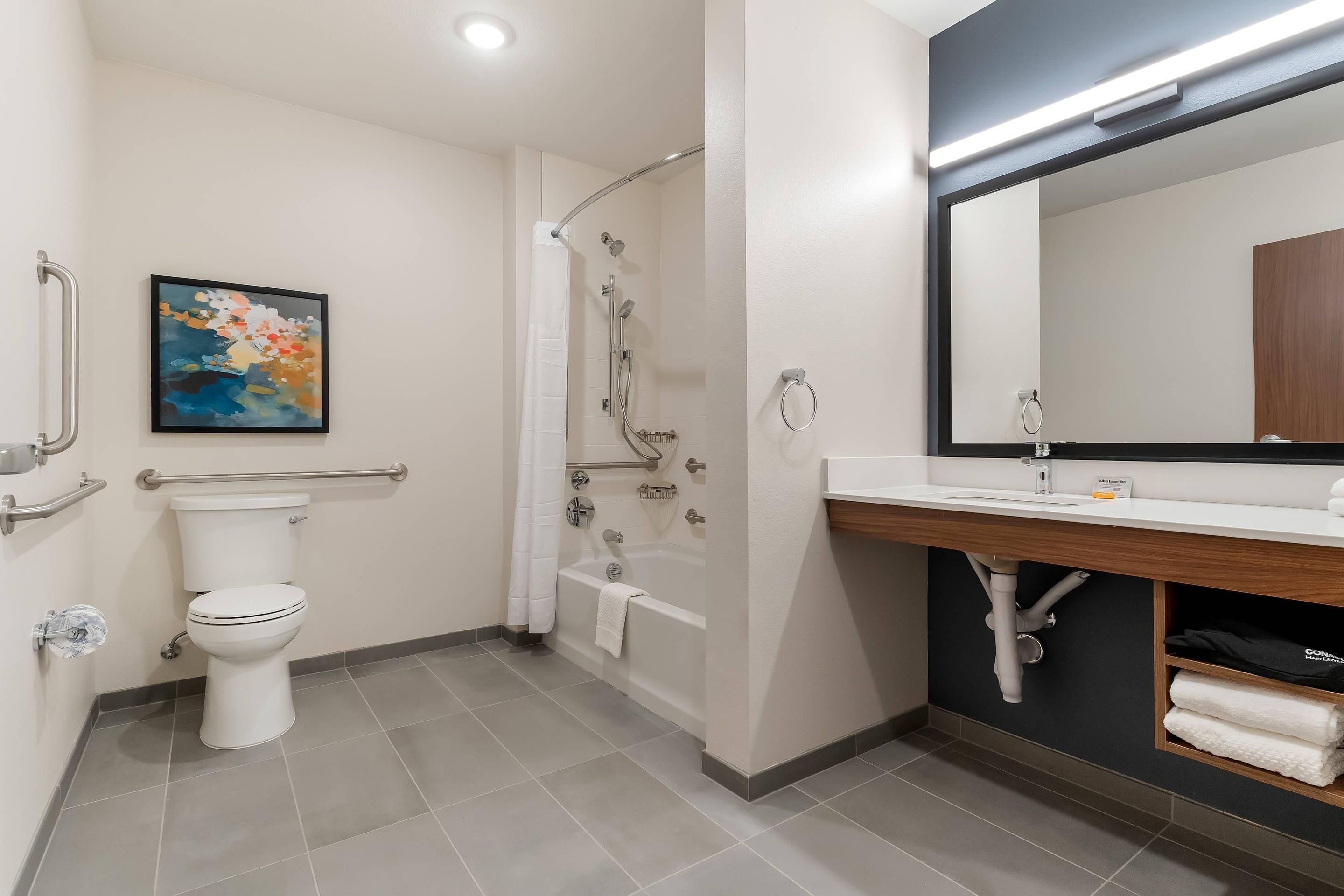 A modern bathroom with a toilet, shower, and sink.