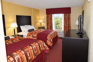 A hotel room with two beds, a desk, a TV, and a window with curtains. - Comfort Inn Stillwater Near University Area (Stillwater)