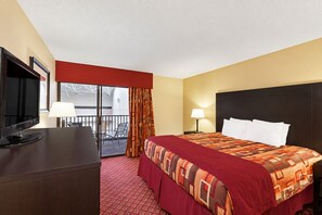 A hotel room with a bed, a desk with a TV, a balcony, and a window. - Comfort Inn Stillwater Near University Area (Stillwater)