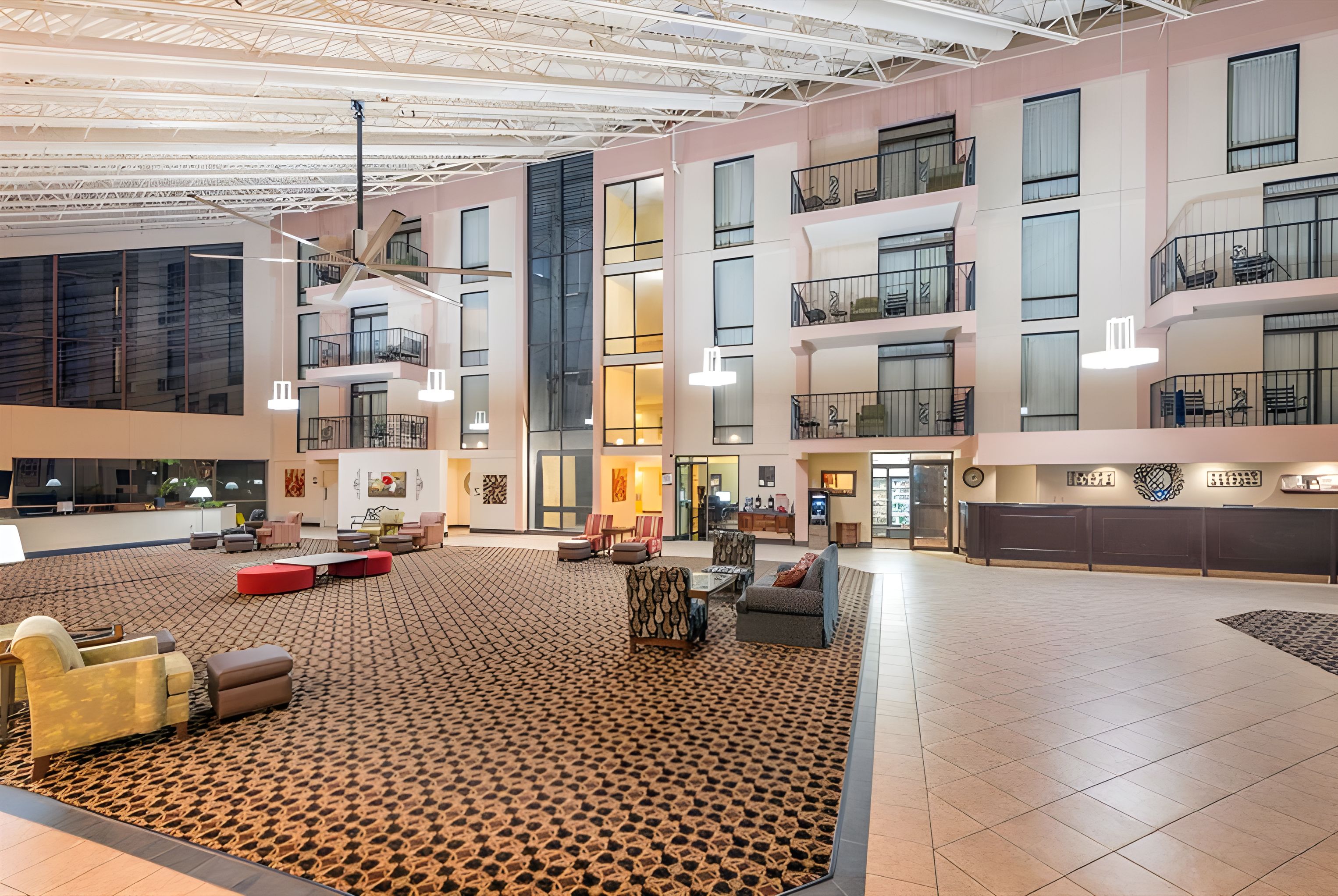 A spacious lobby with a high ceiling, multiple balconies, and a variety of seating arrangements.