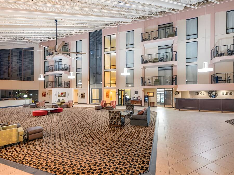 Un hall d’entrée spacieux avec un plafond haut, de nombreux balcons et différents types de sièges.