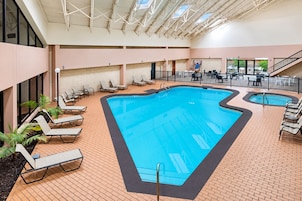 An indoor swimming pool with lounge chairs and a staircase.