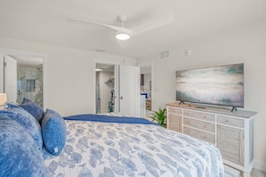 A bedroom with a bed, a TV, a ceiling fan, and a dresser. - NEW! Beachfront Ground Floor: Million $ Views (Sarasota)