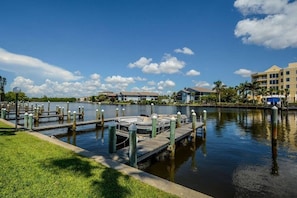 Ein Yachthafen mit vertäuten Booten, ein ruhiger See und Gebäude im Hintergrund.