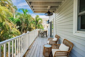 A wooden deck with outdoor furniture, a table, and chairs. - A Hidden Paradise Right Across from Indian Rocks Beach! (Indian Rocks Beach)