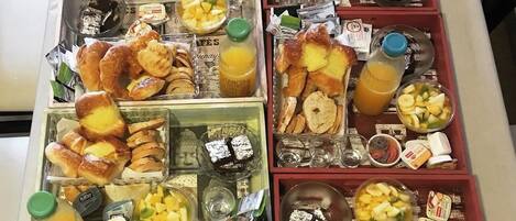 Un bufé de desayuno con diversos pasteles, frutas y bebidas.