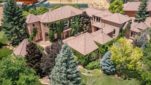 A residential area with multiple houses, each featuring a distinct architectural style, surrounded by lush greenery and trees. - Cottage #1: Italian Resort-Style Villa - 1.4 Acres w/ Pickleball,  In-ground Spa (Parowan)