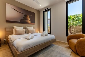 A modern bedroom with a large bed, a view of the outdoors, and a painting on the wall. - Villa Amphitrite • Share, beach & happiness (Agde)