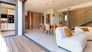 Een modern interieur met een eethoek, keuken en trap.