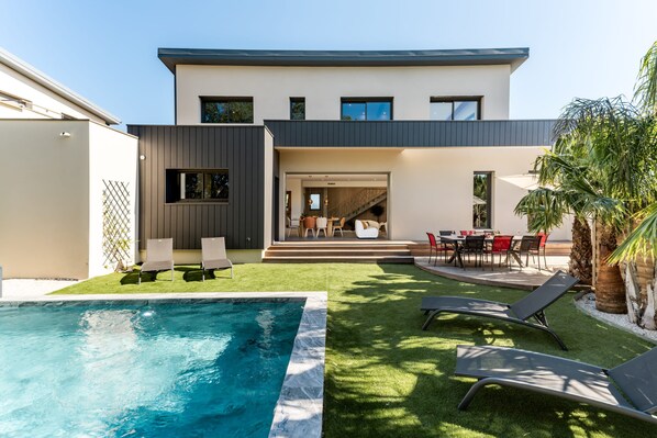 A modern two-story house with a swimming pool, outdoor seating, and a patio area. - Villa Amphitrite • Share, beach & happiness (Agde)
