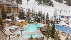 Ein Resort mit mehreren Schwimmbecken, einer Seilbahn und einem Gebäude mit Balkonen.
