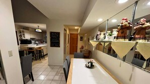 A narrow kitchen with a dining area, a refrigerator, and a chalkboard menu. - Cozy 4-bedroom cottage in superb Conneaut with AC (Conneaut)