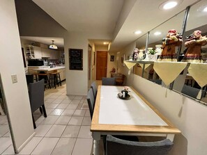 Eine schmale Küche mit Essbereich, einem Kühlschrank und einer Kreidetafel mit Speisekarte.