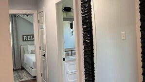 Un pasillo con una cama, un baño y un armario.