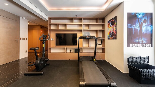 A gym with treadmills, a stationary bike, and a wall-mounted TV. - GA 63 Ape com AR prox Allianz e Einstein (São Paulo)