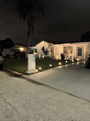 A residential house with a driveway, a mailbox, and a lawn. - Cozy chic 2-bedroom house in Port Richey with screened in pool (Port Richey)
