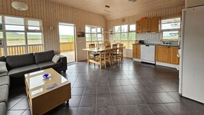 En rummelig opholdsstue med sofa, sofabord og spisebord.