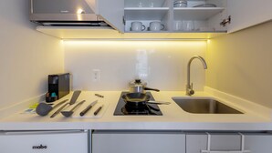 Een moderne keuken met een ingebouwde magnetron, fornuis en spoelbak.