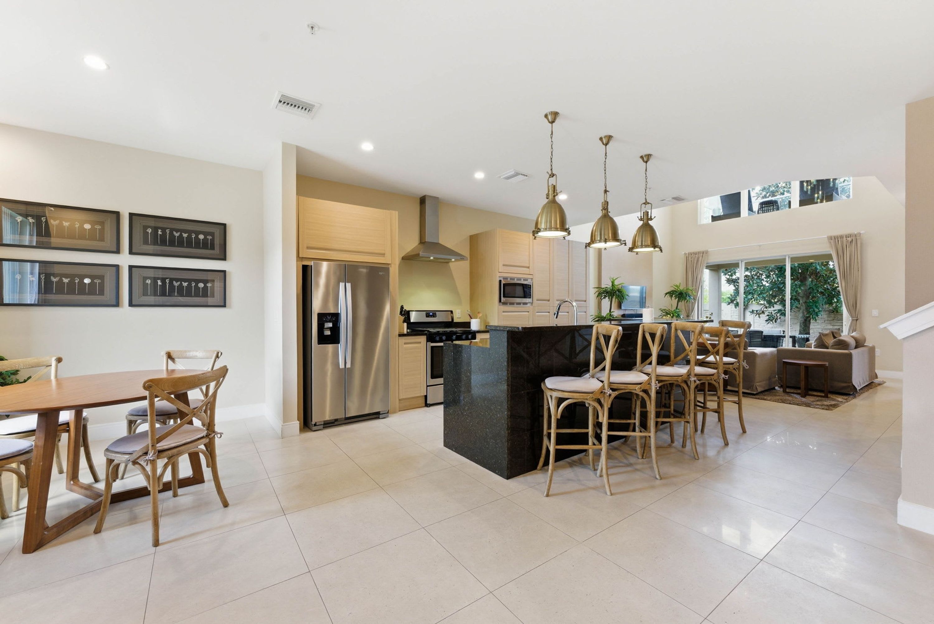 A modern kitchen with a central island, stainless steel appliances, and pendant lighting.