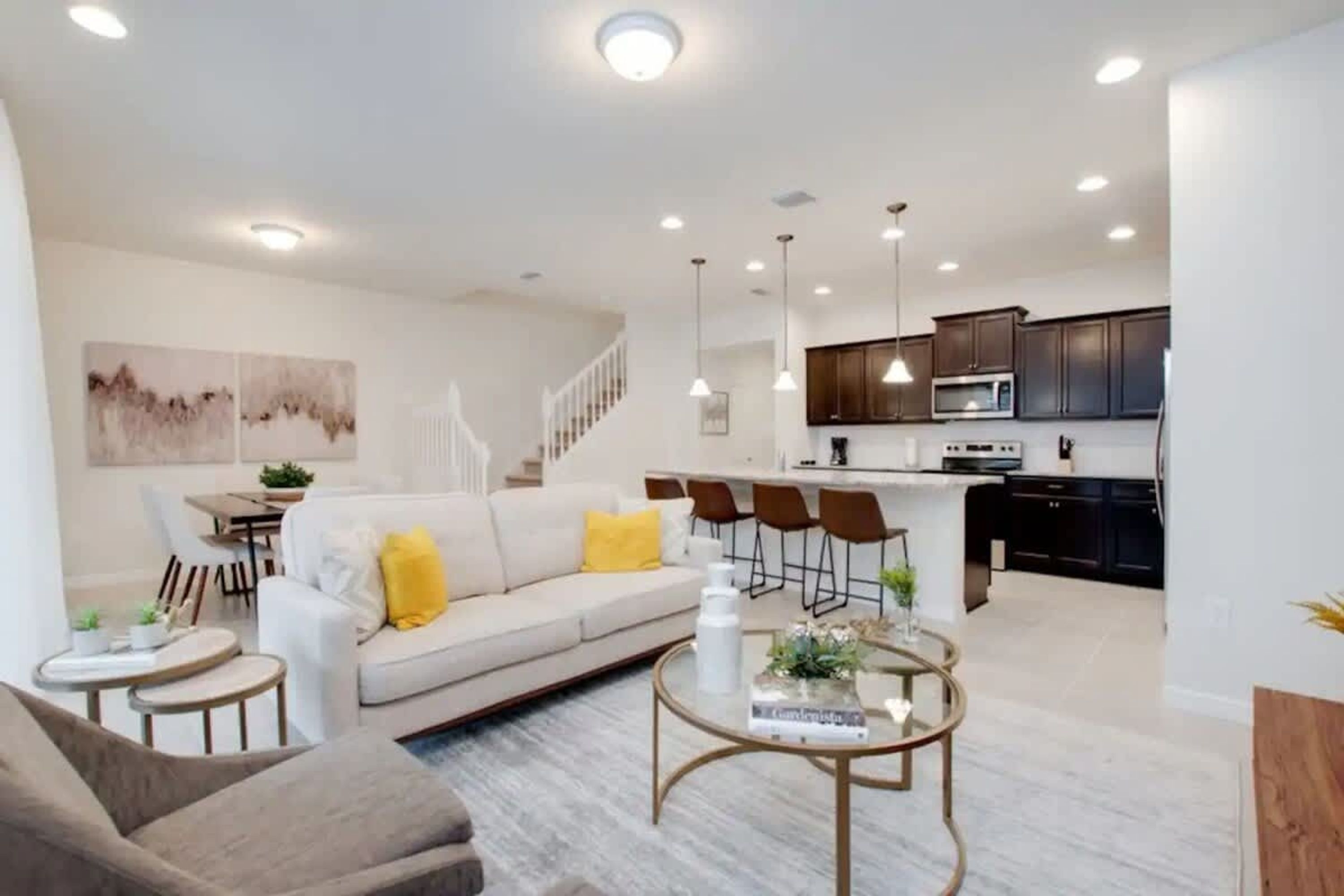 A modern living room with a sofa, coffee table, and a dining area with chairs.