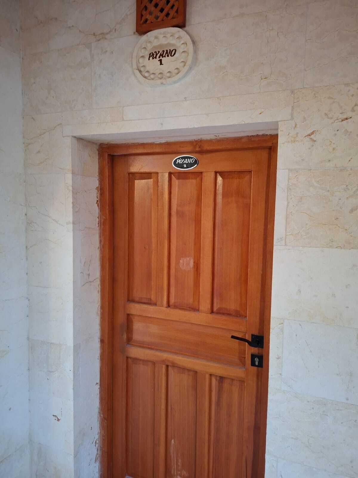 Una puerta de madera con un letrero encima que dice 'PIVANO 1'.