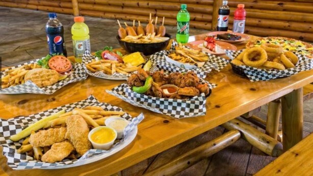 Een houten tafel met verschillende soorten eten en drinken.