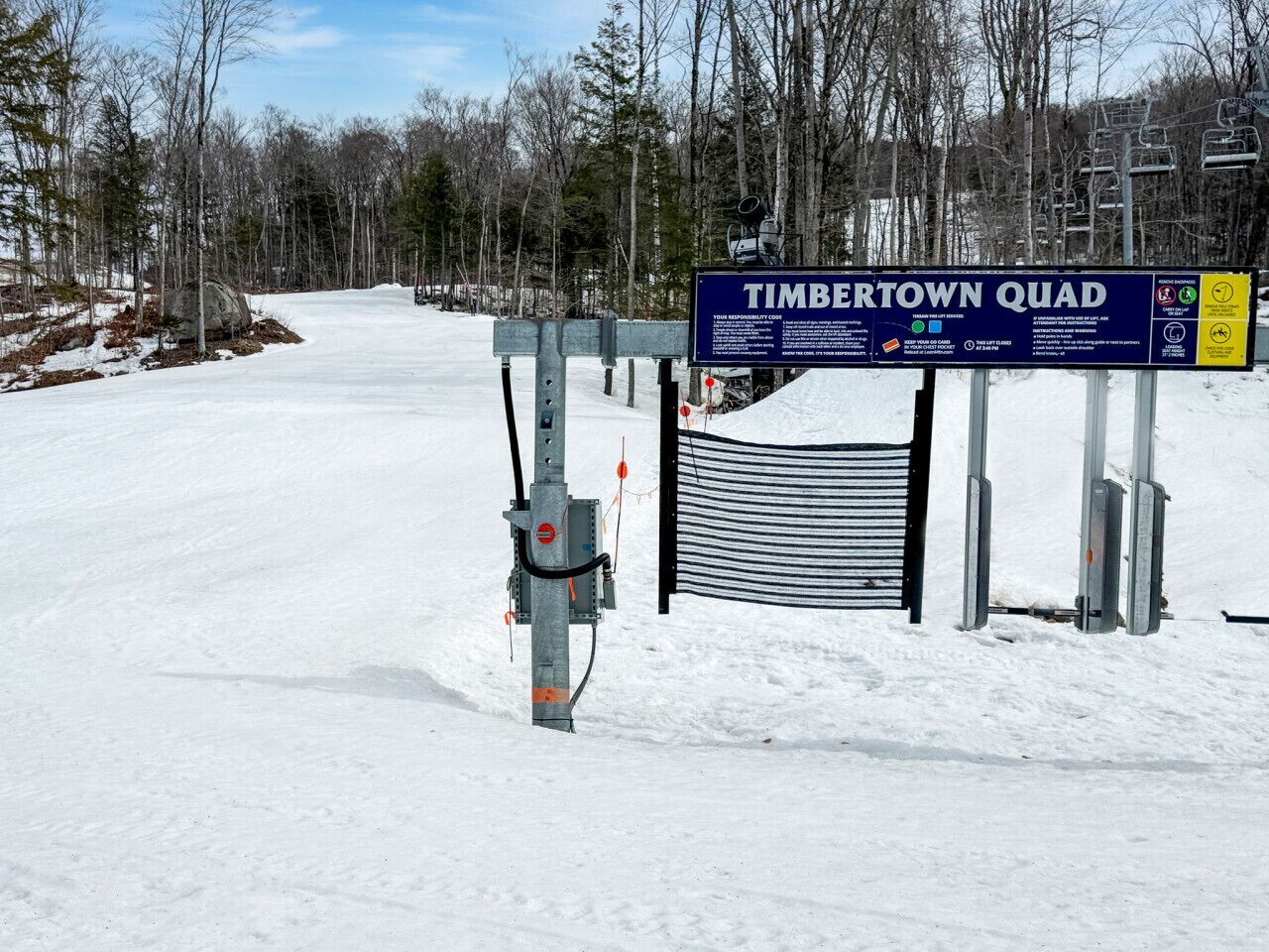 Lumipeitteinen sisäänkäynti hiihtokeskukseen, jonka yhteydessä on kyltti, jossa lukee Timbertown Quad.