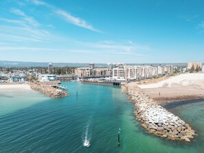 A coastal hotel with a marina, waterfront views, and a rocky shoreline.