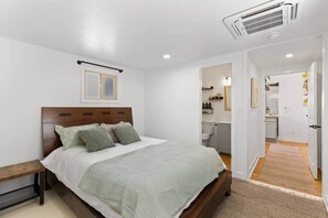Een slaapkamer met een bed, nachtkastje en een raam.