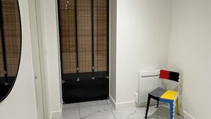 A room with a tiled floor, a door with a window, and a chair with a colorful backrest. - Peaceful and spacious T3 in the heart of Bordeaux (Bordeaux)