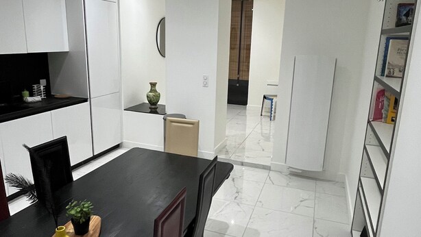 A modern kitchen with white cabinets, a dark dining table, and a potted plant on the counter. - Peaceful and spacious T3 in the heart of Bordeaux (Bordeaux)