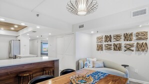 A modern kitchen with a wooden island, white cabinetry, and a built-in refrigerator. - 603 Villa Madeira White Sand Beachfront Condo with Stunning Sunsets (Madeira Beach)