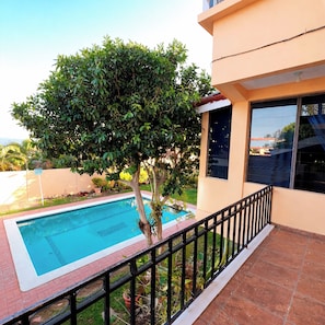A swimming pool, a tree, and a building with a balcony. - Gioventu  (San Salvador)