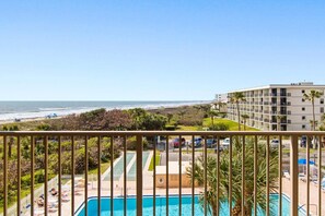 A hotel with a pool, a view of the beach, and a parking lot. - Oceanfront Condo With Private Balcony & Heated Pool! 🏝️☀️ (Cape Canaveral)