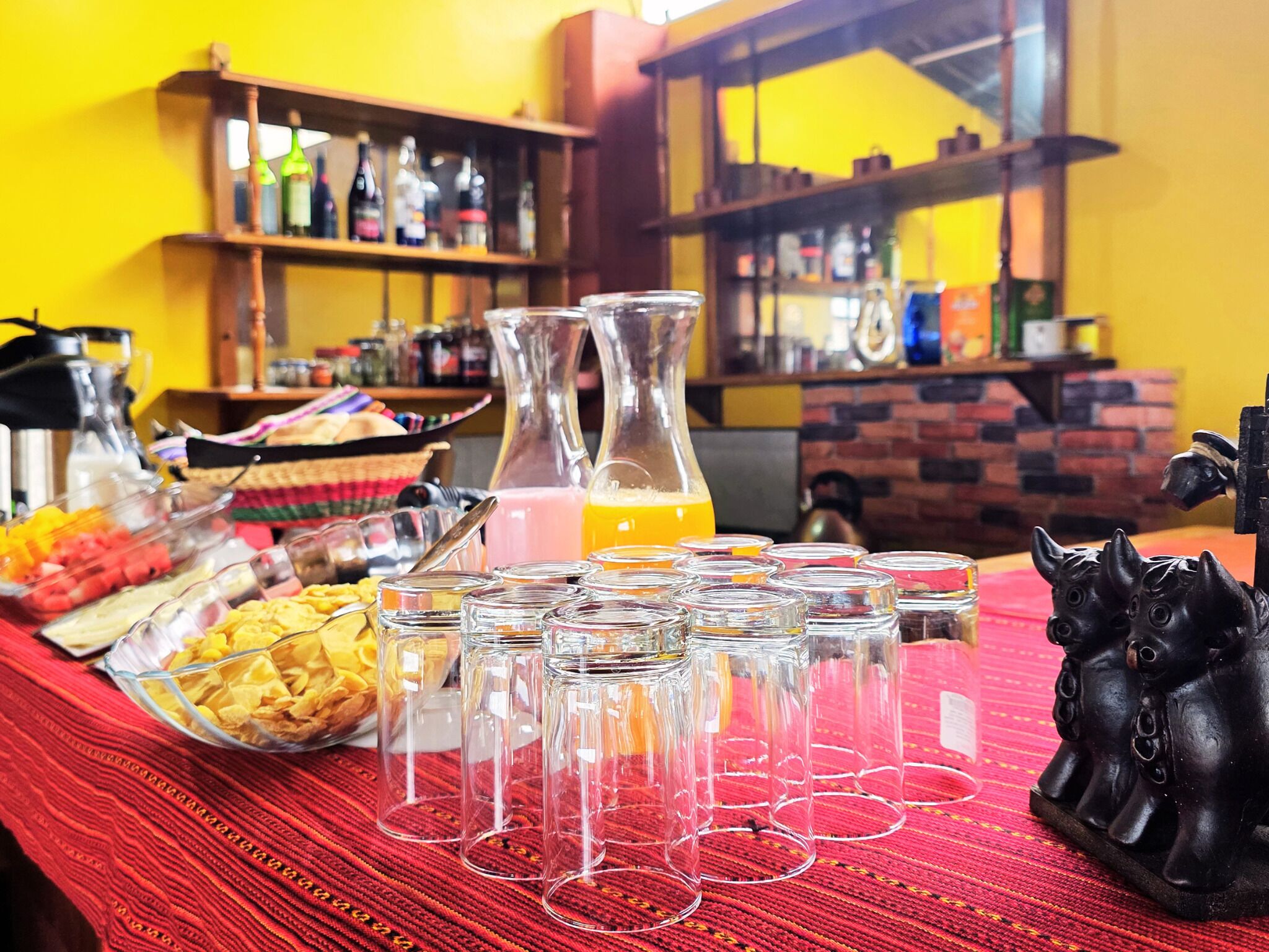 A buffet table with various food items and a pitcher of orange juice.